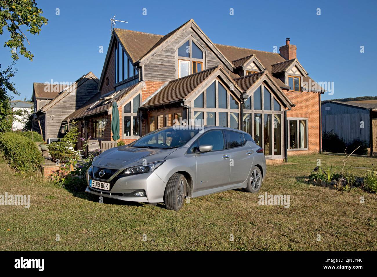 Grigio metallizzato Nissan Leaf e-connetta EV auto elettrica parcheggiata fuori ecohouse Cotswolds UK Foto Stock