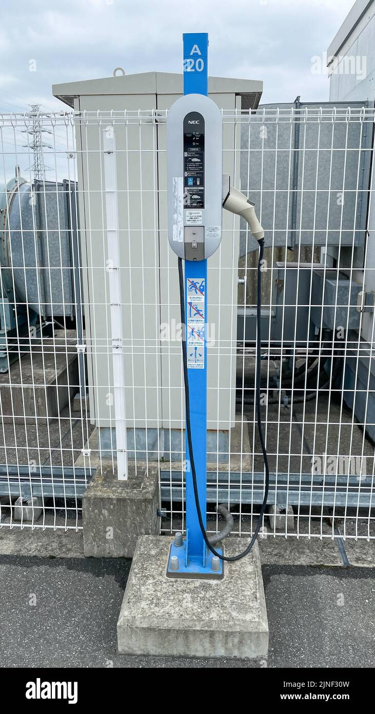 Caricabatterie per veicoli elettrici standard NEC Corp. Blu e bianco in cima a un parcheggio sul tetto presso un centro commerciale EON. Foto Stock