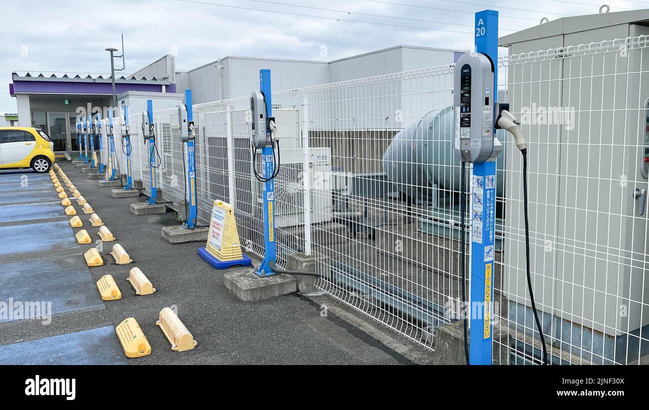 Una fila di caricabatterie per veicoli elettrici standard NEC Corp. In cima a un parcheggio sul tetto presso un centro commerciale EON con una sola ricarica per auto presso uno degli stans Foto Stock