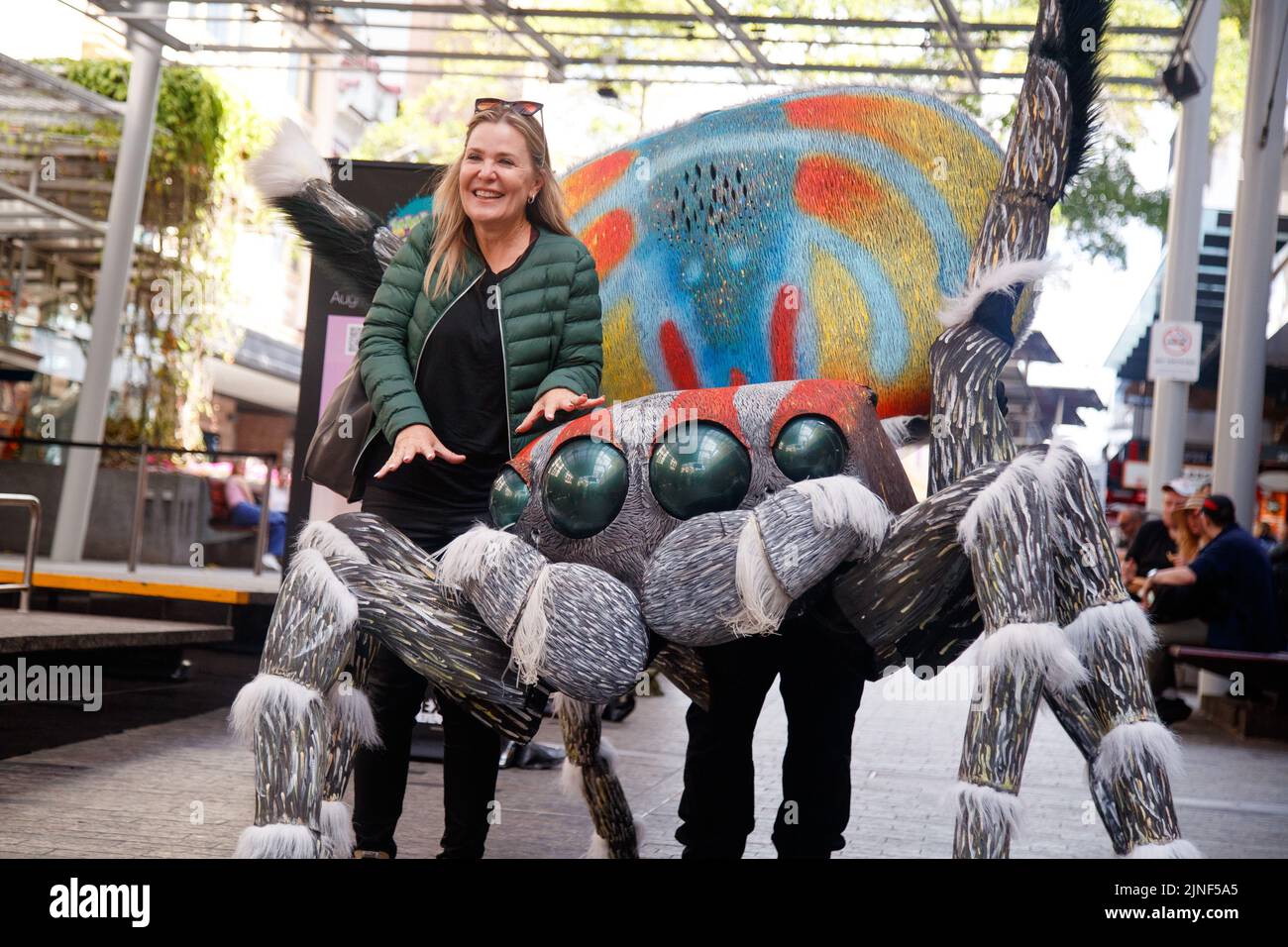 Brisbane, Australia. 11th ago, 2022. Una donna posa con una persona in un costume gigante Peacock Spider nel Queen Street Mall di Brisbane al lancio della National Science Week il 11 agosto 2022. Esperimenti dal vivo e mostre di esemplari museali sono state eseguite nel Queen Street Mall di Brisbane per il lancio della National Science Week. La National Science Week è stata fondata nel 1997 per riconoscere il contributo degli scienziati e della tecnologia australiani. (Foto di Joshua Prieto/Sipa USA) Credit: Sipa USA/Alamy Live News Foto Stock