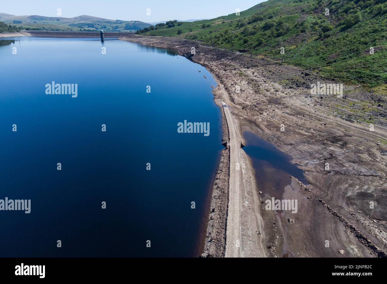 Llyn Celyn, Gwynedd, Galles 11 agosto 2022 - la vecchia ferrovia Bala and Ffestiniog è emersa dalle profondità dopo che il livello dell'acqua continua a scendere. La linea ferroviaria è stata inondata insieme al villaggio di Capel Celyn nel 1965 per creare il controverso lago Llyn Celyn Reservoir a Gwynedd il serbatoio fornisce acqua alla città di Liverpool. Fig. Per credito: Interrompi stampa Media/Alamy Live News Foto Stock