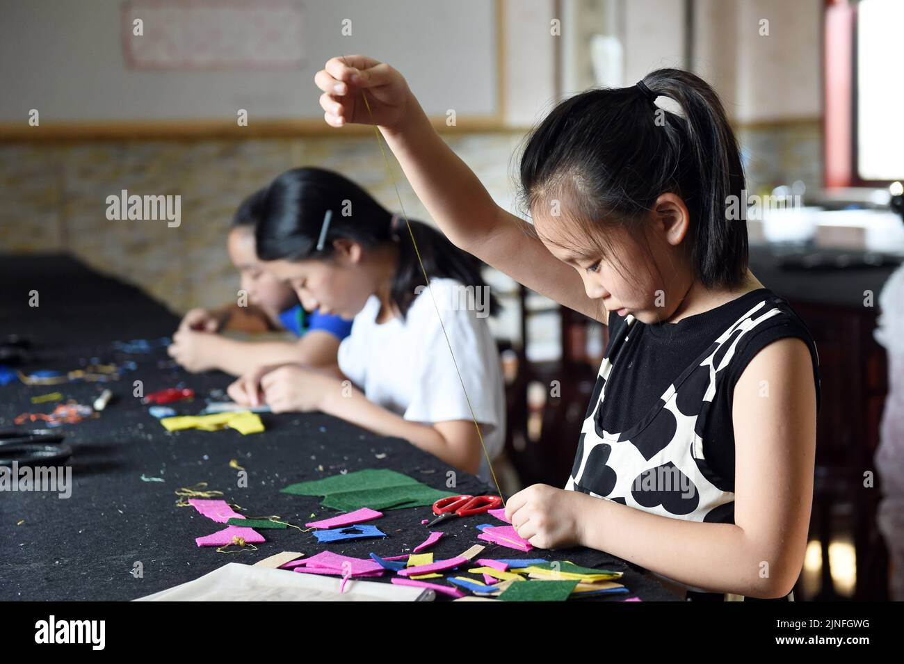 (220811) -- HEFEI, 11 agosto 2022 (Xinhua) -- gli studenti imparano il ricamo a Hefei, nella Provincia Anhui della Cina orientale, 10 agosto 2022. Alcune scuole di Hefei ora forniscono servizi gratuiti di asilo nido per gli studenti questa estate. I programmi di cure diurne non solo aiutano ad arricchire l'estate degli studenti, ma anche ad alleviare la pressione sui genitori che lavorano, altrimenti, devono prendersi cura dei loro figli durante le vacanze. (Xinhua/Zhou Mu) Foto Stock