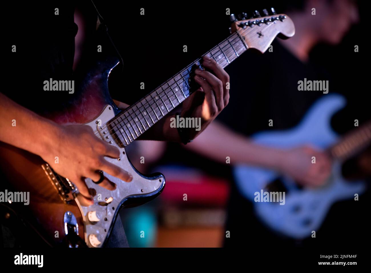 Un uomo che suona la chitarra nel campo estivo Foto Stock