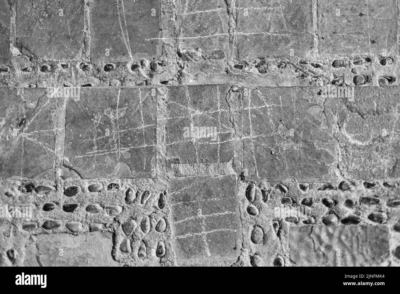 Un vecchio gioco di piazze su un muro in bianco e nero in Marocco Foto Stock