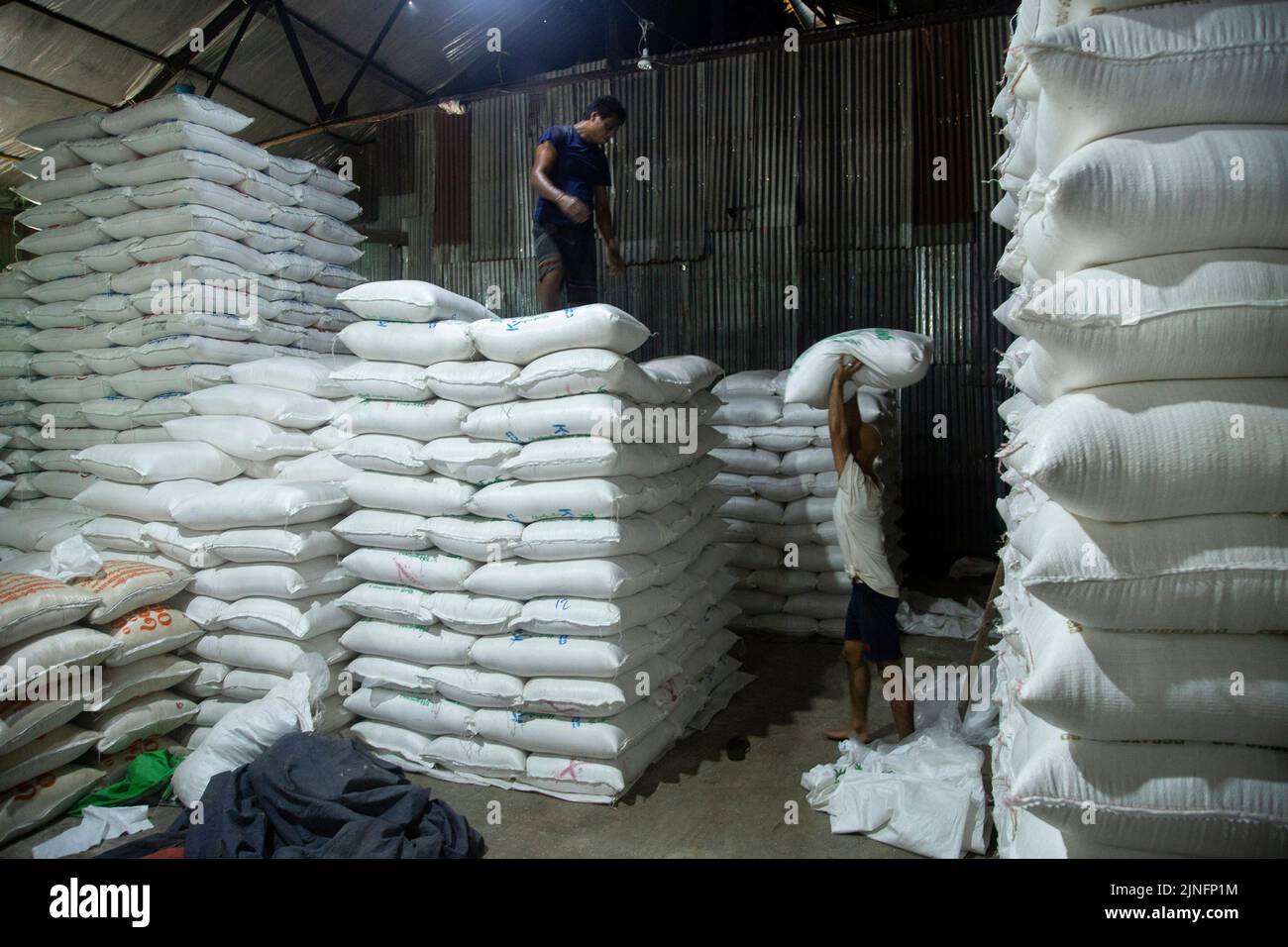 Yangon. 11th ago, 2022. I lavoratori accatastano sacchi di riso in un magazzino a Yangon, Myanmar il 11 agosto 2022. I proventi delle esportazioni agricole del Myanmar sono diminuiti del 1,25 per cento a circa 1,27 miliardi di dollari USA su base annuale nei primi quattro mesi dell'attuale anno fiscale (FY) 2022-2023, secondo il Ministero del Commercio. Il paese del sud-est asiatico ha cambiato il proprio anno fiscale dall'ottobre-settembre originale ad aprile-marzo a partire da quest'anno. Credit: MYO Kyaw Soe/Xinhua/Alamy Live News Foto Stock