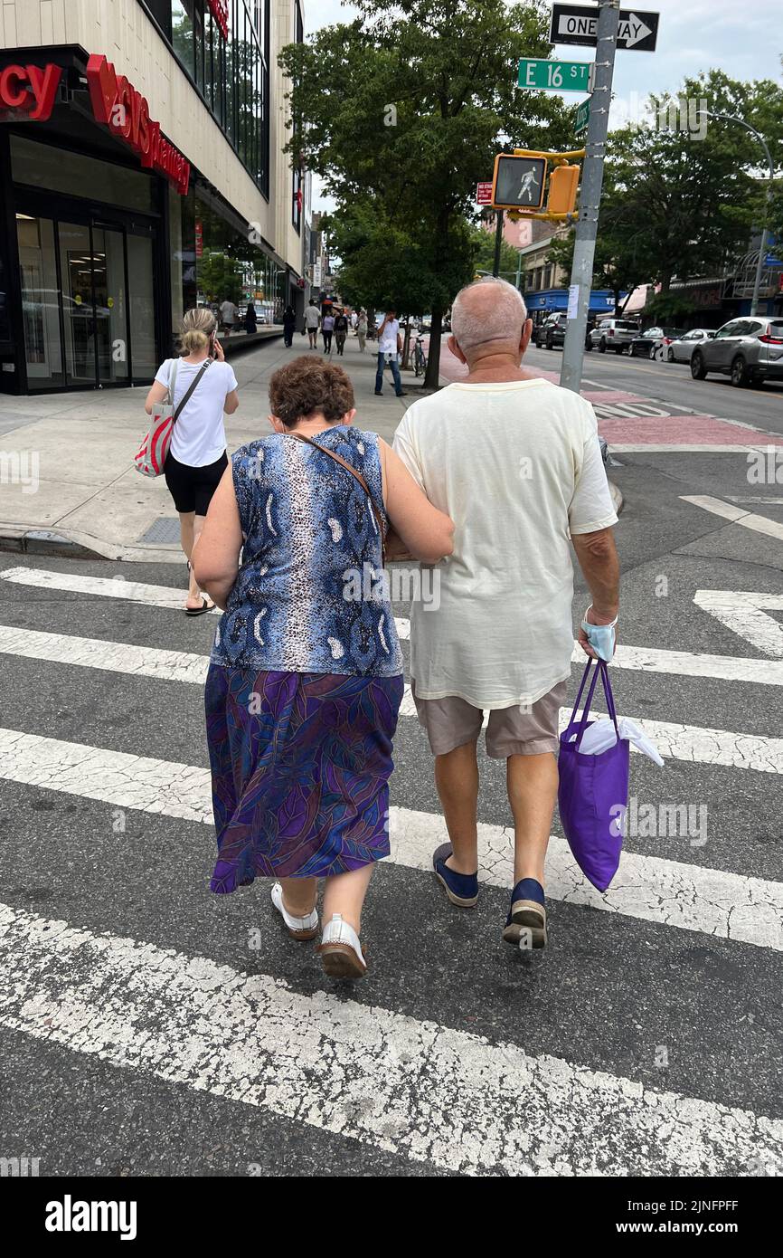 Una coppia più anziana fa shopping lungo la Kings Highway nel quartiere di Midwood in una calda giornata estiva a Brooklyn, New York. Foto Stock