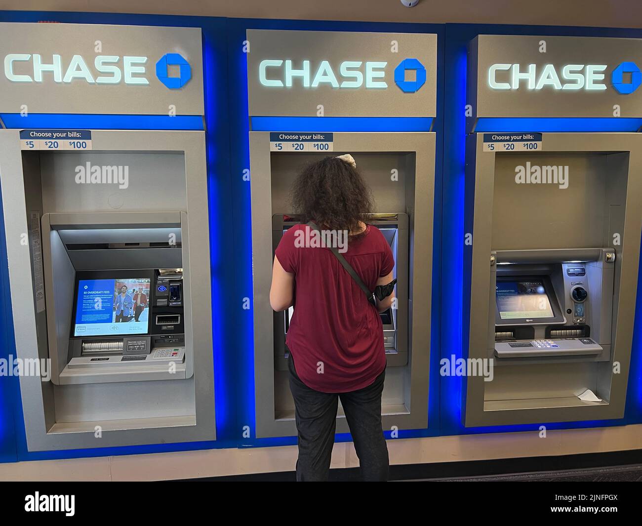 La donna deposita assegni e ritira contanti presso un bancomat Chase nella lobby della filiale a New York City. Foto Stock