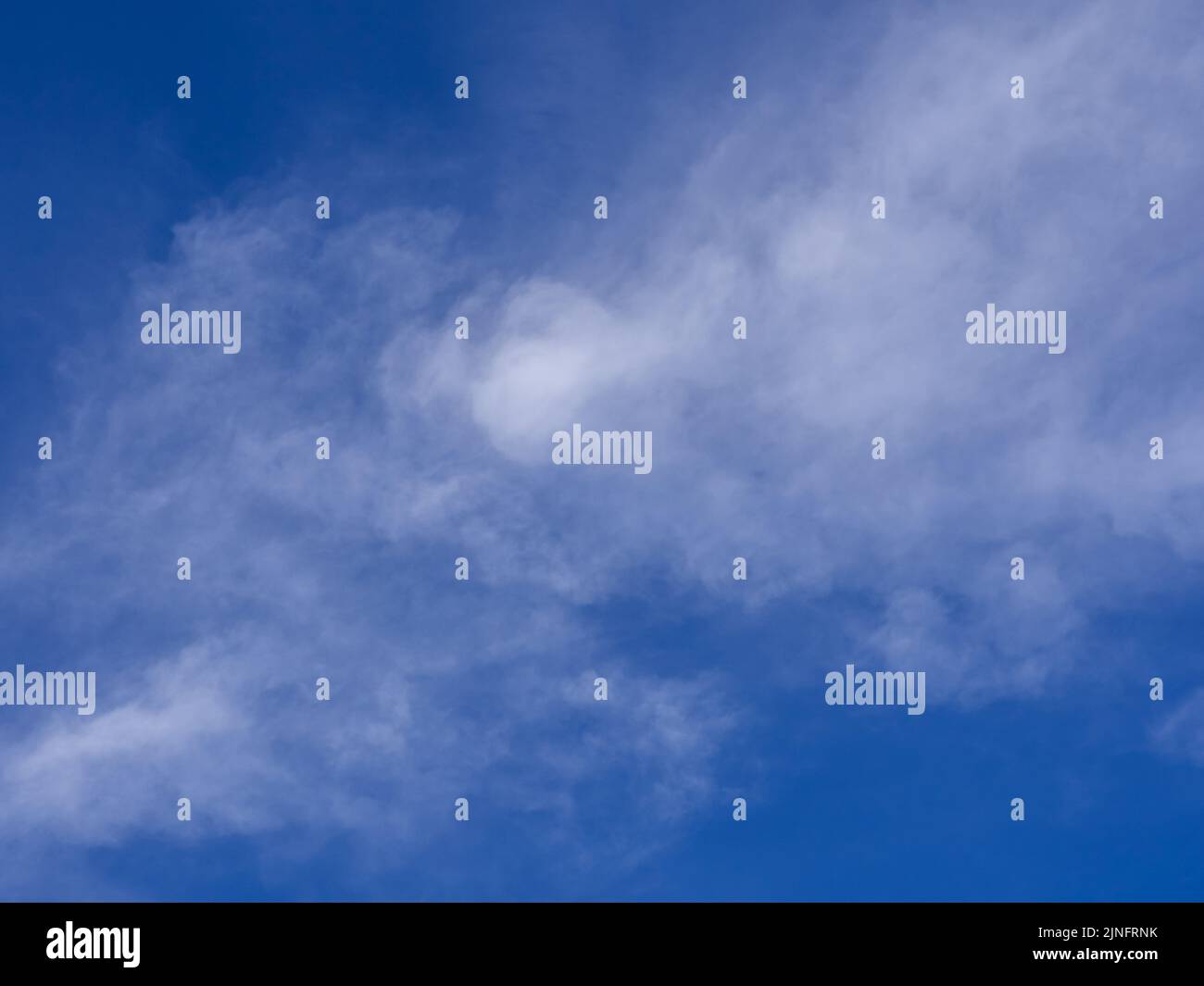 Soffici nuvole fluttuanti sparse nel cielo Foto Stock