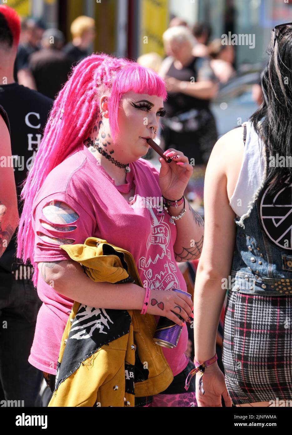 Blackpool, Lancashire, Regno Unito Agosto 6 2022 Una ragazza punk con capelli vividi e top fuma un vape durante il Blackpool Rebellion Punk Festival Foto Stock