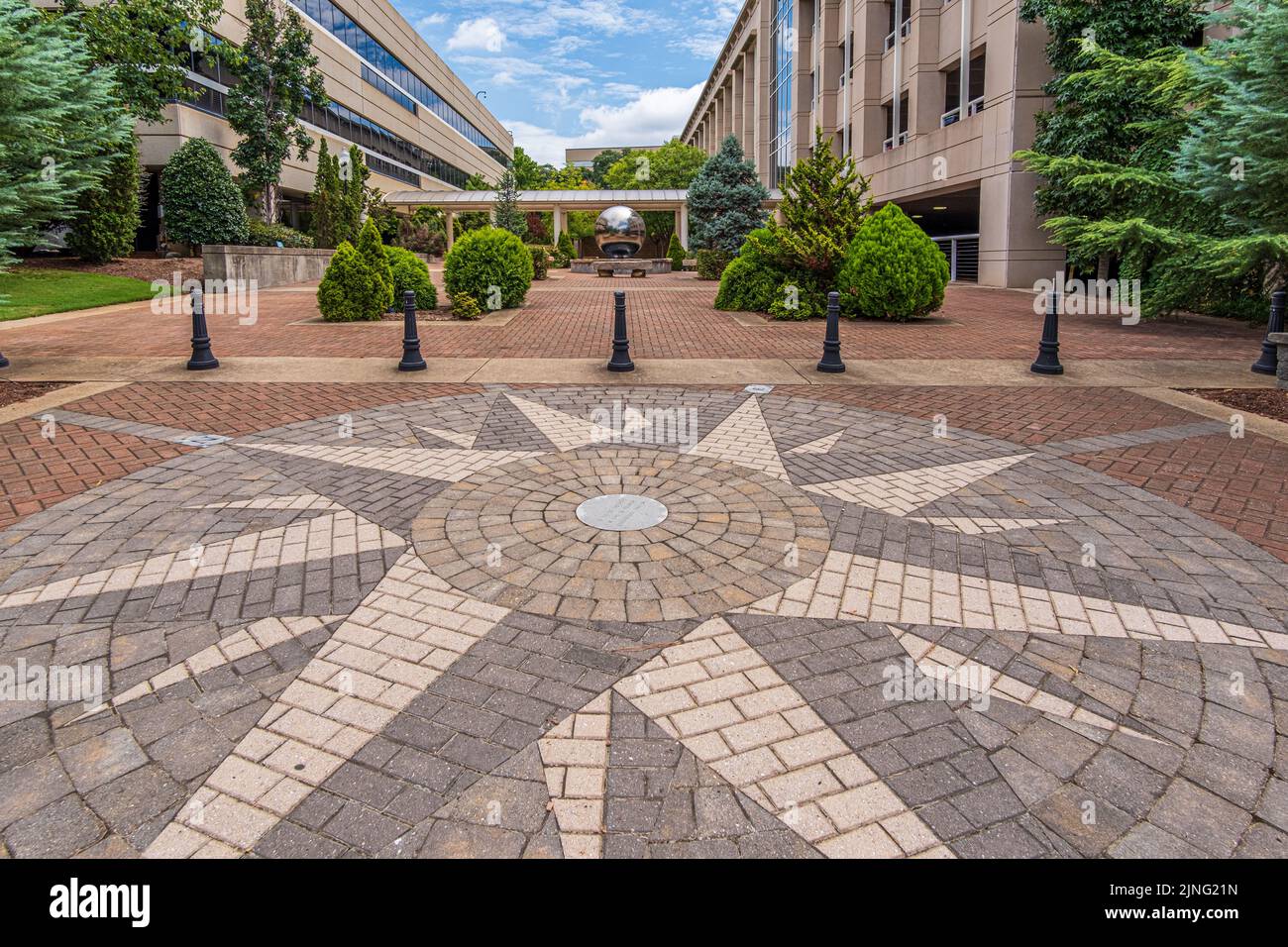 Paesaggio urbano a Spartanburg, South Carolina, con bussola in mattoni rosa e fontana d'acqua con palla d'argento nell'area del parco tascabile. Foto Stock