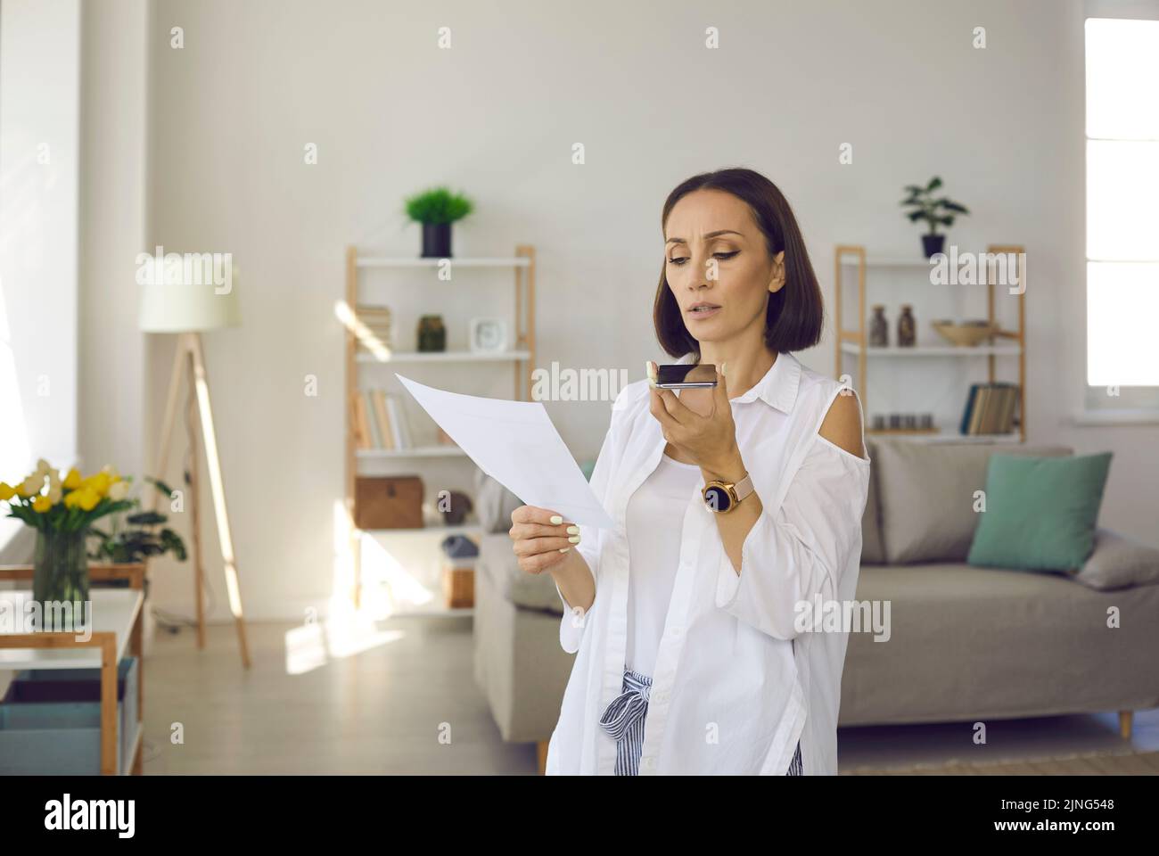 Donna che registra un messaggio vocale aziendale o che parla con l'altoparlante sul suo cellulare Foto Stock