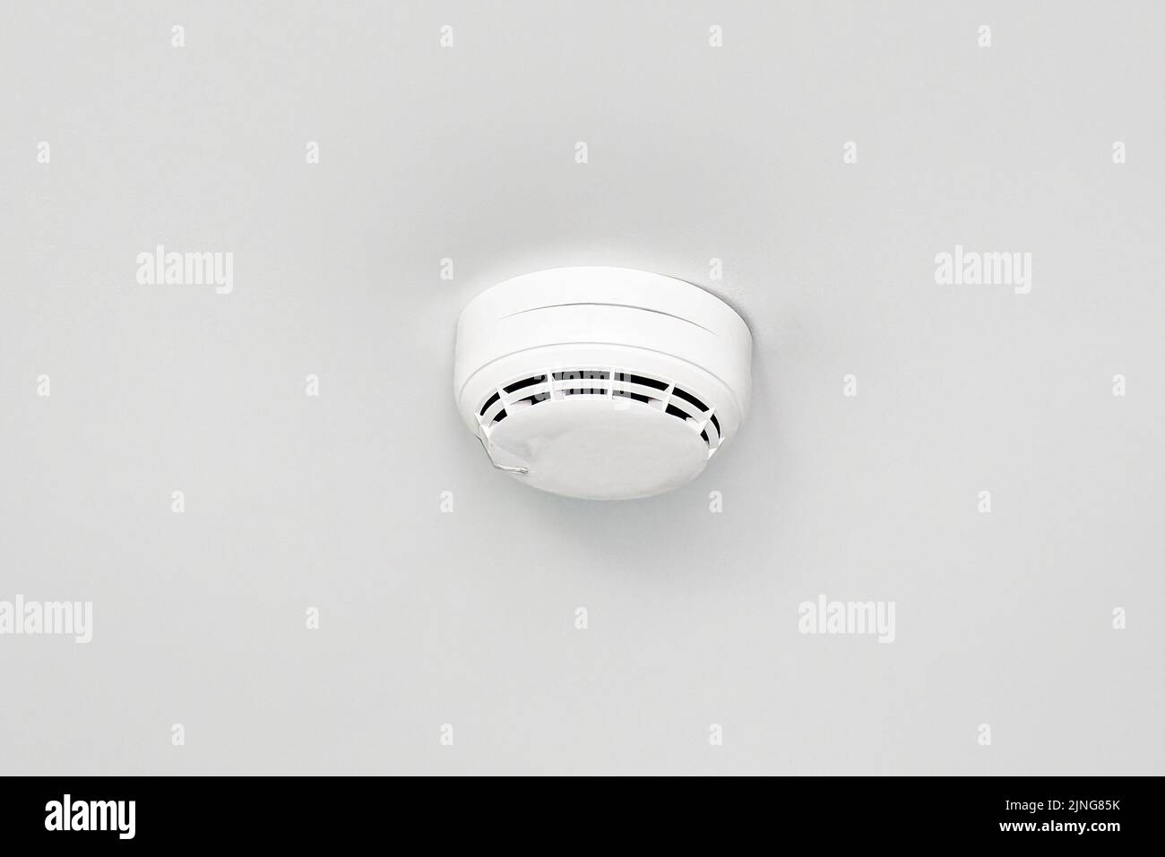Rilevatore di fumo o sensore di allarme antincendio su soffitto bianco. Foto Stock
