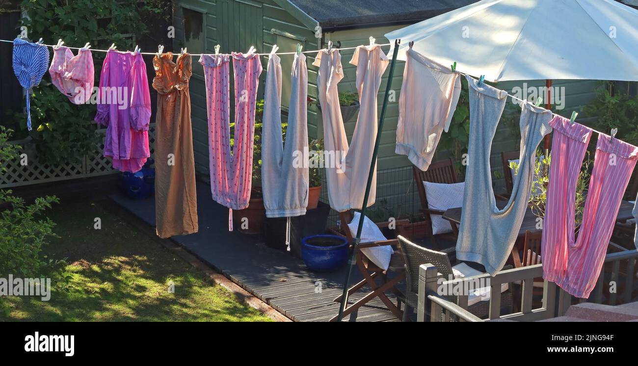 Tipica linea di lavaggio del giardino sul retro, con i vestiti che asciugano sotto il sole caldo e la brezza, piuttosto che sprecare elettricità in asciugatrice Foto Stock
