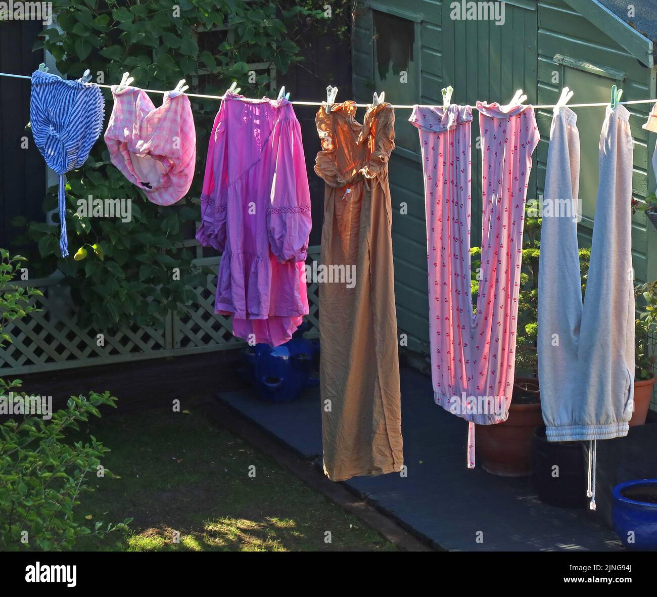 Tipica linea di lavaggio del giardino sul retro, con i vestiti che asciugano sotto il sole caldo e la brezza, piuttosto che sprecare elettricità in asciugatrice Foto Stock