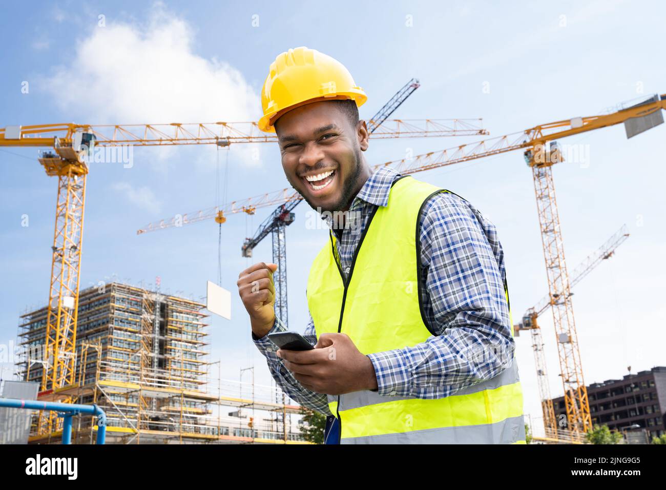Vincitore entusiasta Construction Builder Worker Engineer che utilizza il telefono Foto Stock