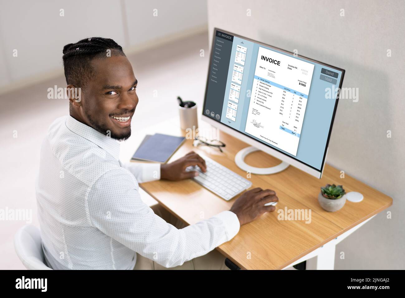 Imprenditore lavora su computer con fattura sullo schermo del computer in ufficio Foto Stock