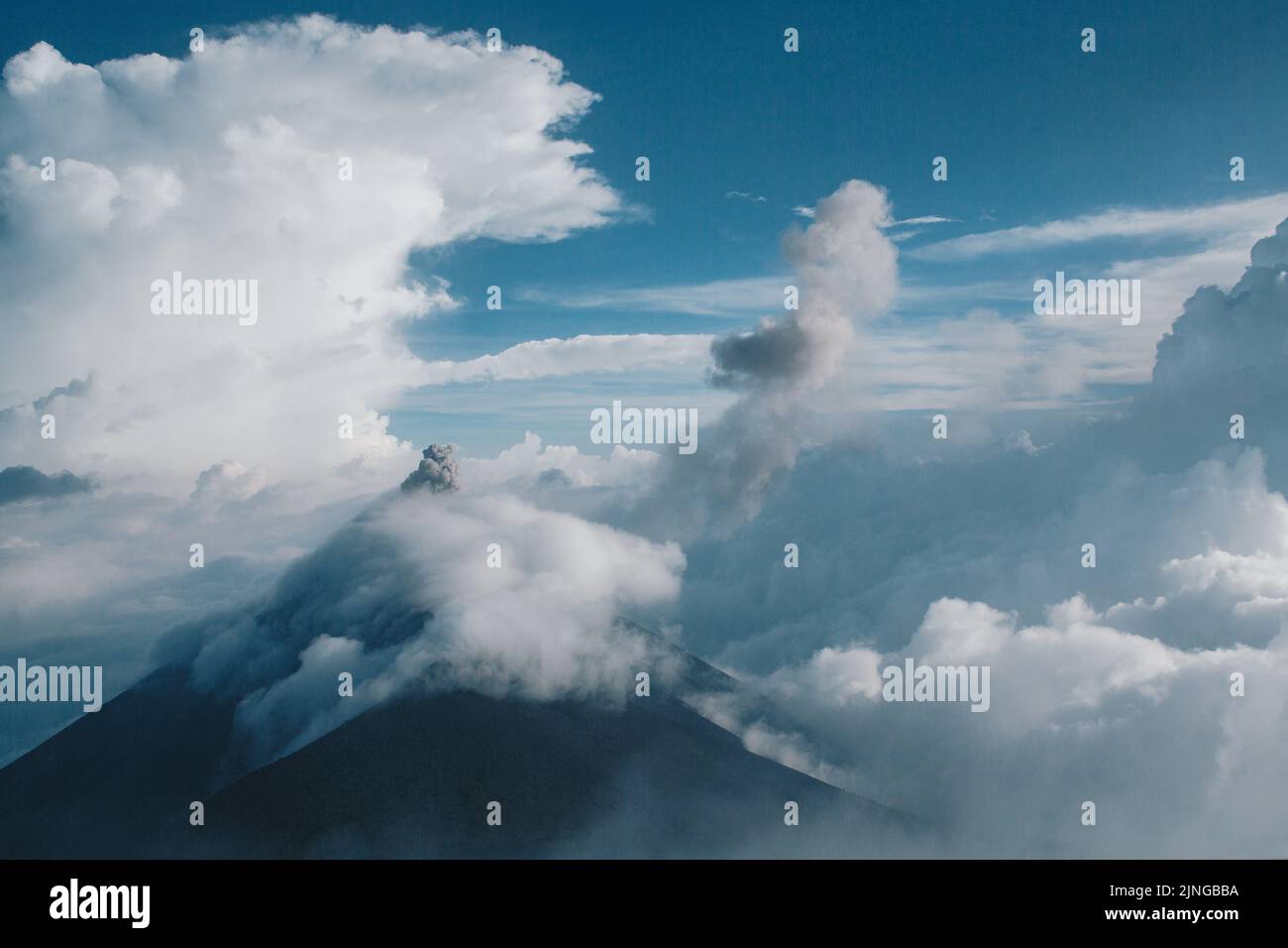 Un Volcan de Fuego coperto da nubi fredde prima di un tramonto imminente con una tempesta di temporali. Foto Stock