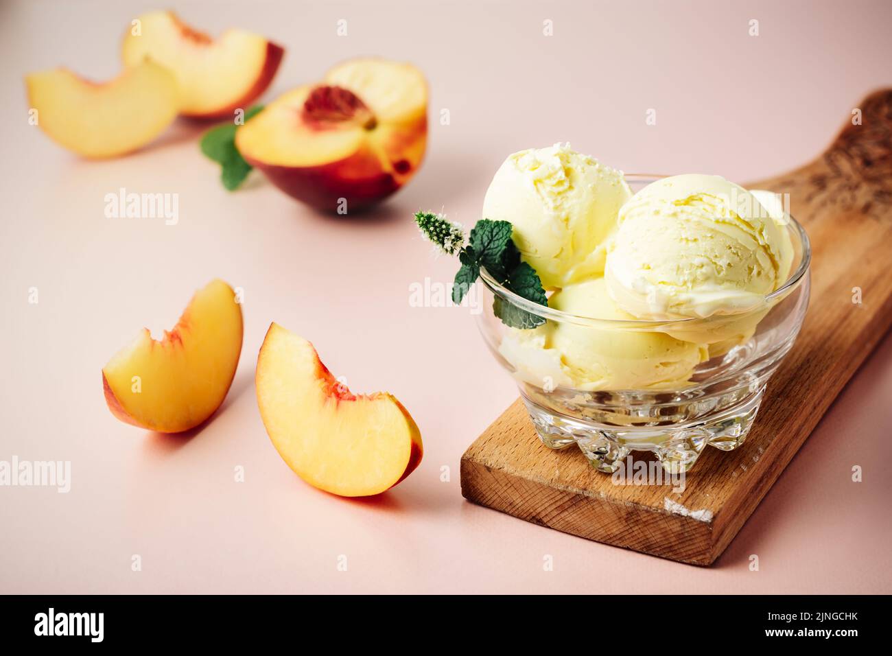 Cucchiaio di gelato alla pesca in un bicchiere. Foto Stock