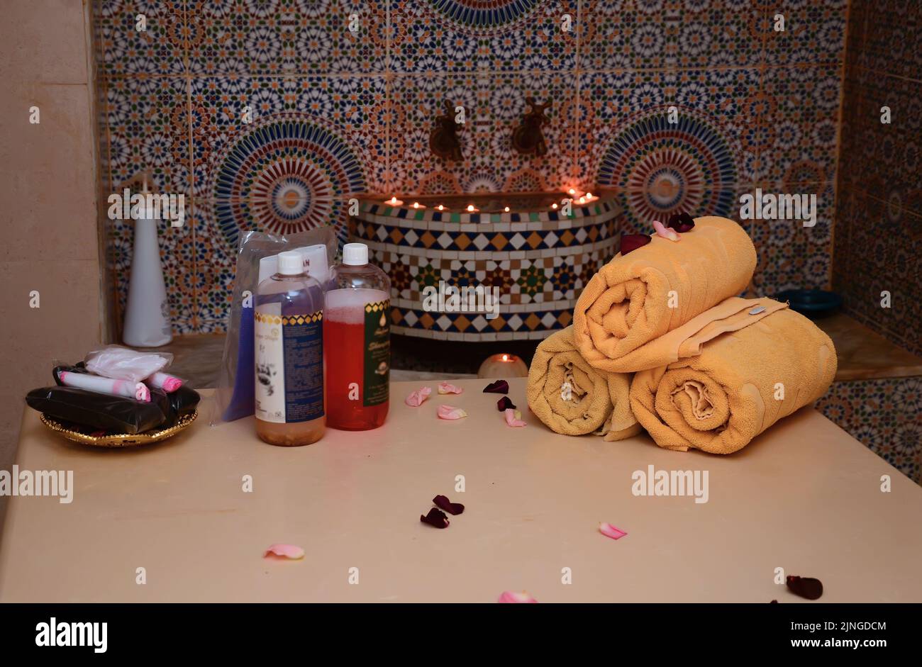 Bombe da bagno e polvere di argilla marocchina, composizione termale con pennello e candele accese su sfondo bianco Foto Stock