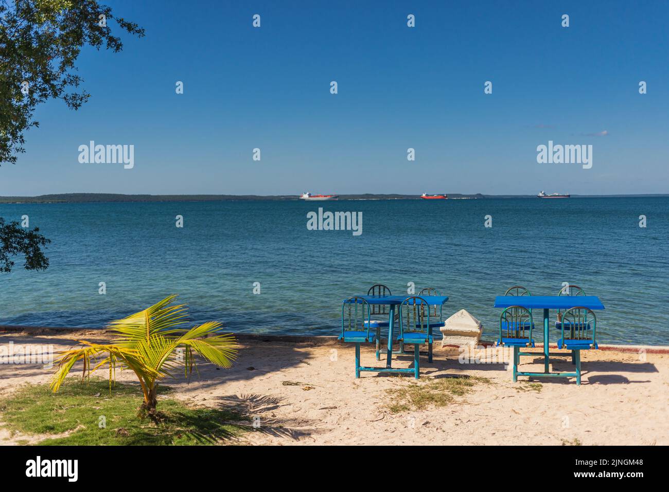 Vista sulla baia di Cienfuegos, Cuba con sedie da picnic blu. Foto Stock