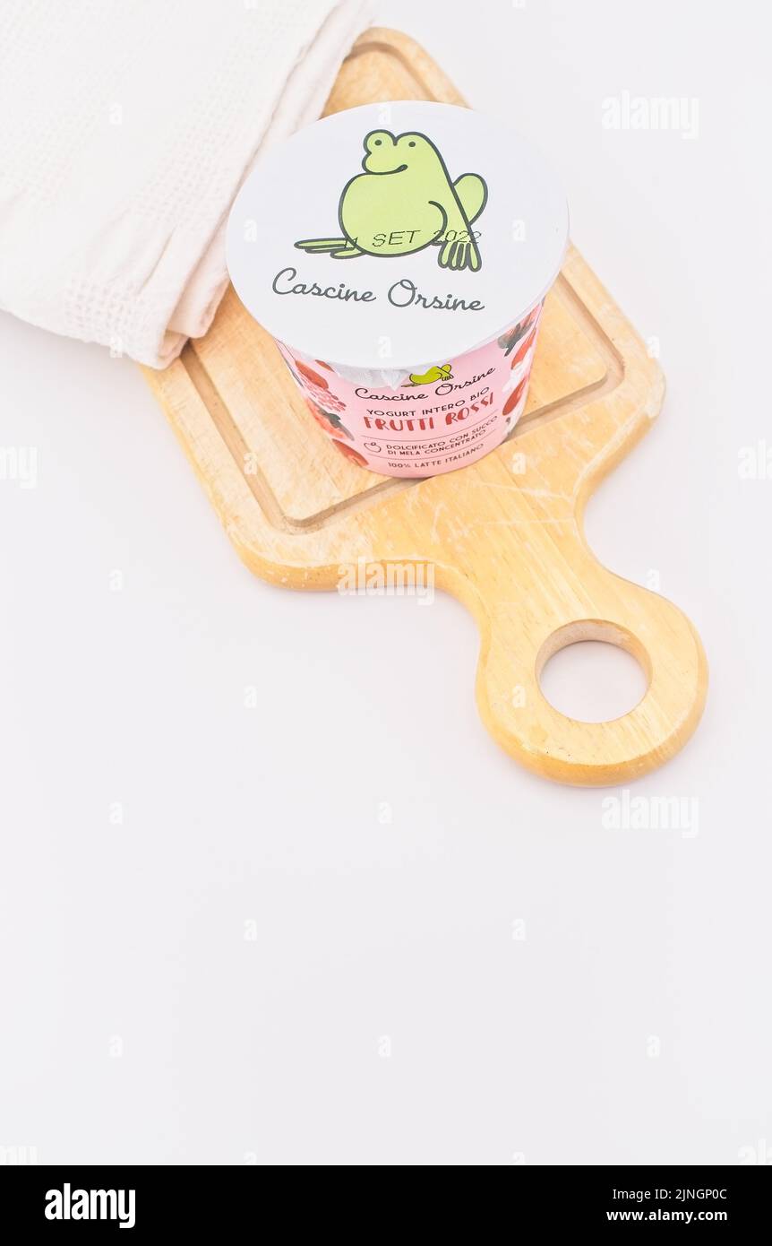 bacche rosse agricoltura biologica yogurt vaso con utensili da cucina su un tavolo bianco sfondo - dieta e sana nutrizione concetto Foto Stock