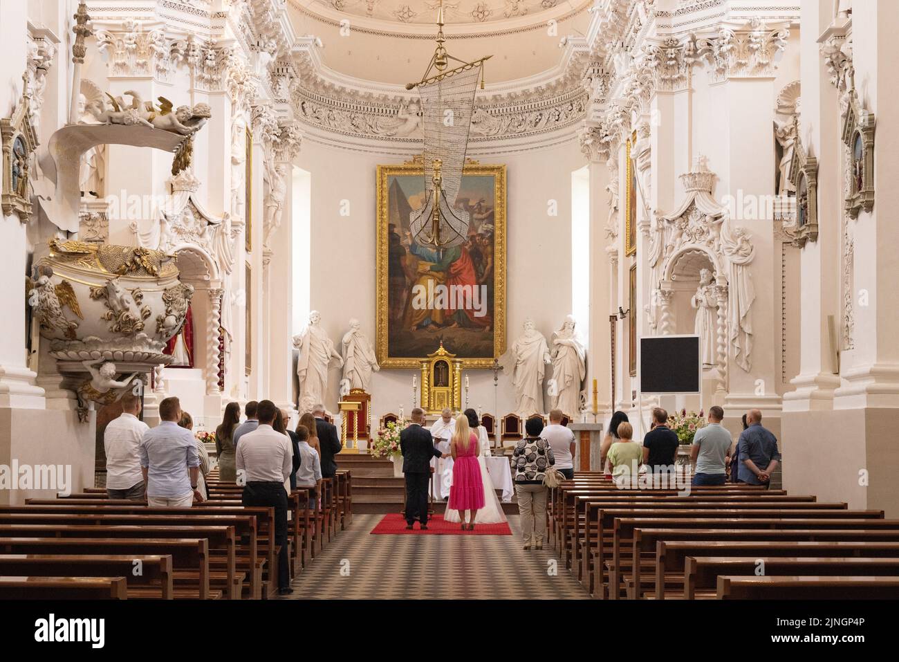 Un servizio di matrimonio cattolico, e il matrimonio, con la congregazione, all'interno della Chiesa di San Pietro e San Paolo, Vilnius, Lituania Europa Foto Stock