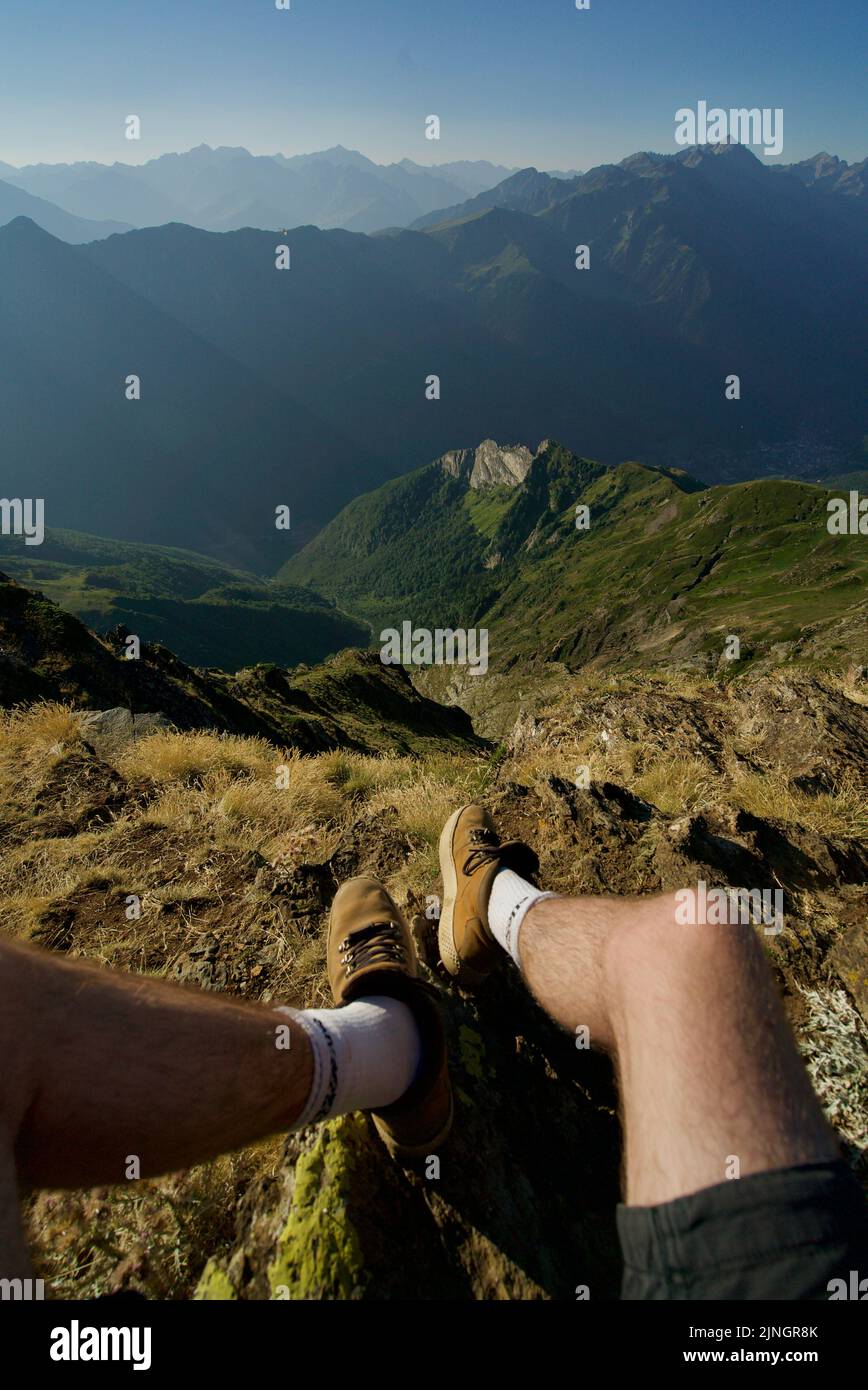 Foto POV sulla cima di una montagna, piedi che pendono sopra una montagna, nei Pirenei Orientali, Francia. Foto di viaggio sospesa ai piedi. PIC de Cabaliros. Foto Stock
