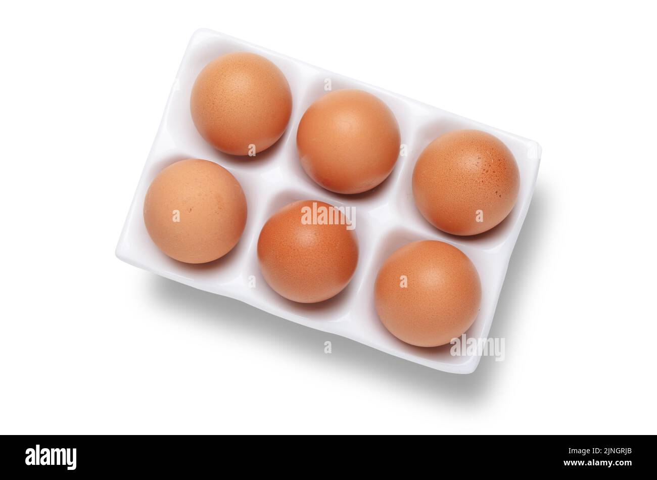 Mezza dozzina o sei uova di gallina in vassoio di ceramica bianco o shot di supporto dall'alto isolato su bianco con ritaglio percorso di ritaglio Foto Stock