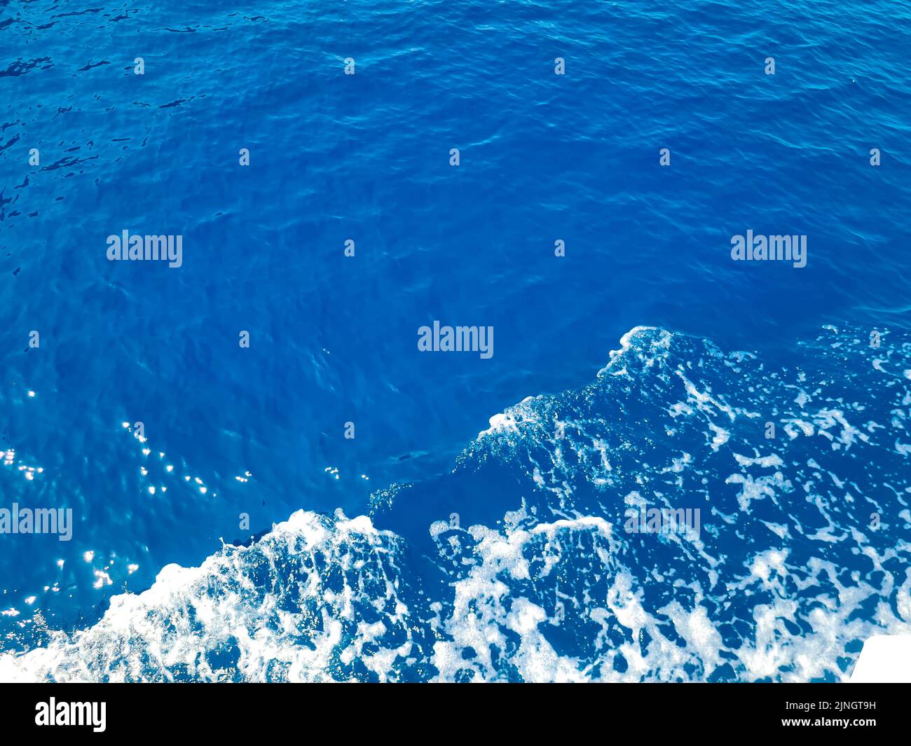 Superficie blu profonda di acqua di mare trasparente con lubrole di sole Foto Stock