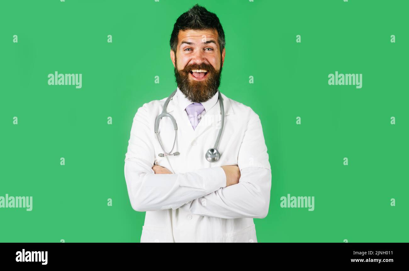 Sorridente medico maschio con braccia piegate. Bel medico portatore in camice da laboratorio con stetoscopio. Foto Stock