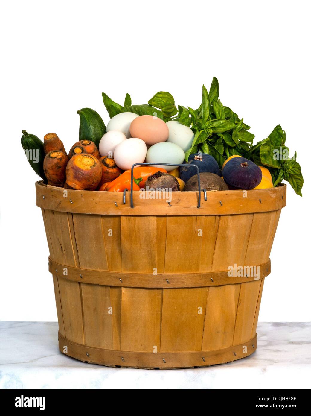 Cestino con frutta, verdura e uova della raccolta estiva californiana su sfondo bianco, isolato, su tavola di marmo, vista laterale, centrato Foto Stock