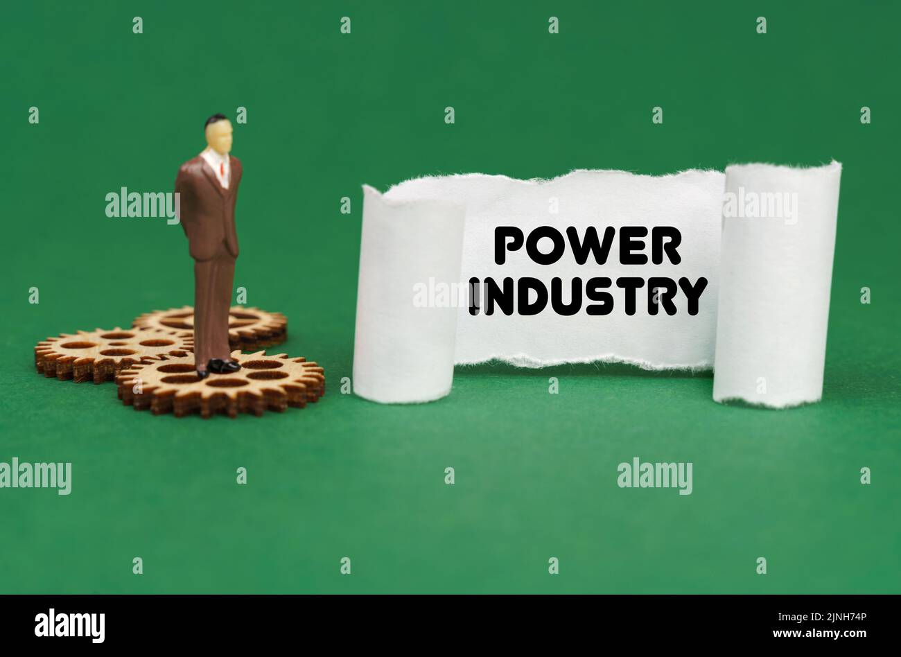 Concetto aziendale. La figura di un uomo è in piedi sugli ingranaggi e legge l'iscrizione - Power Industry su carta Foto Stock