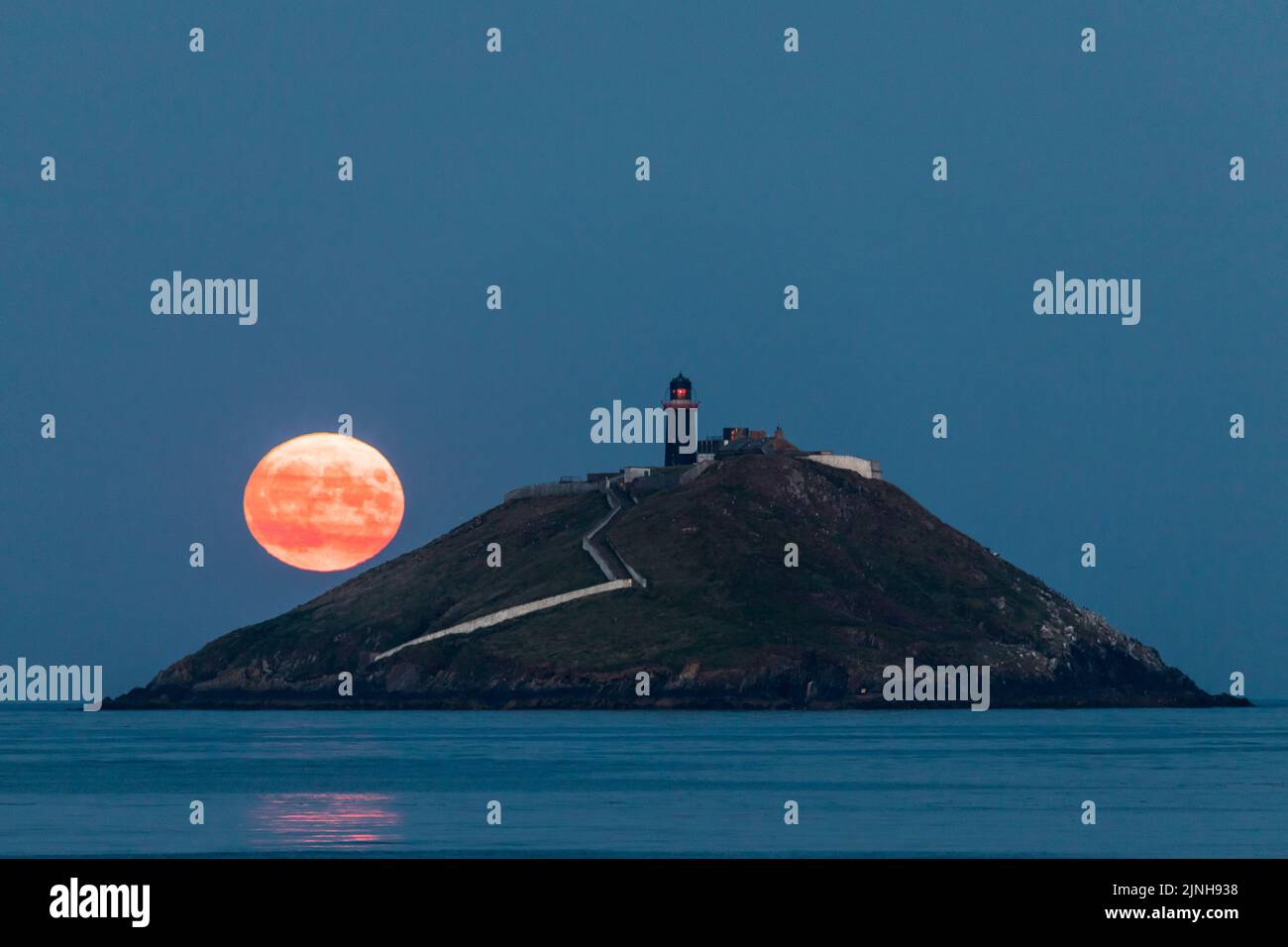 Ballycotton, Cork, Irlanda. 11th agosto, 2022. Una Sturgeon Moon sorge dietro il faro di Ballycotton Bay, Co. Cork, Irlanda. - Credit; David Creedon / Alamy Live News Foto Stock