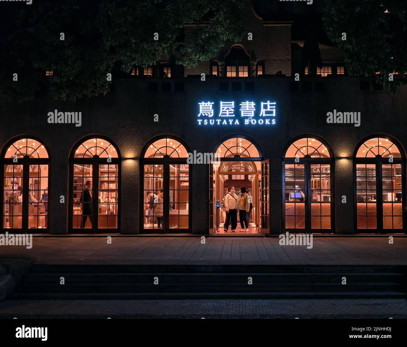 Una piccola e bella libreria a Shanghai, Cina chiamato Tsutaya Books con il segno blu che si illuminano di notte Foto Stock