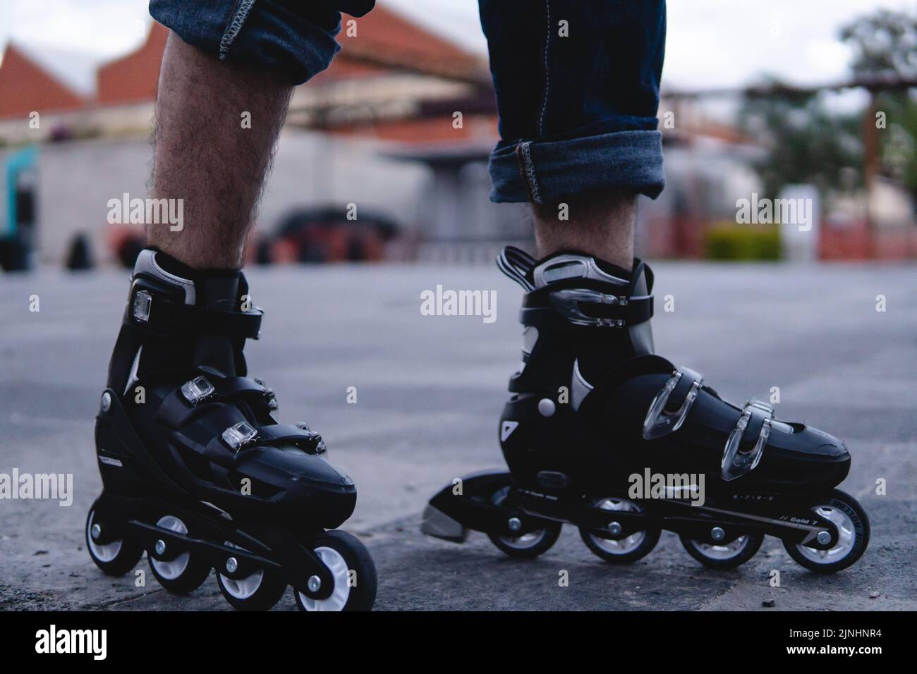 Primo piano di una coppia di pattini esterni. I pattini sono bianchi e neri. Piedi con pattini. Foto di alta qualità Foto Stock