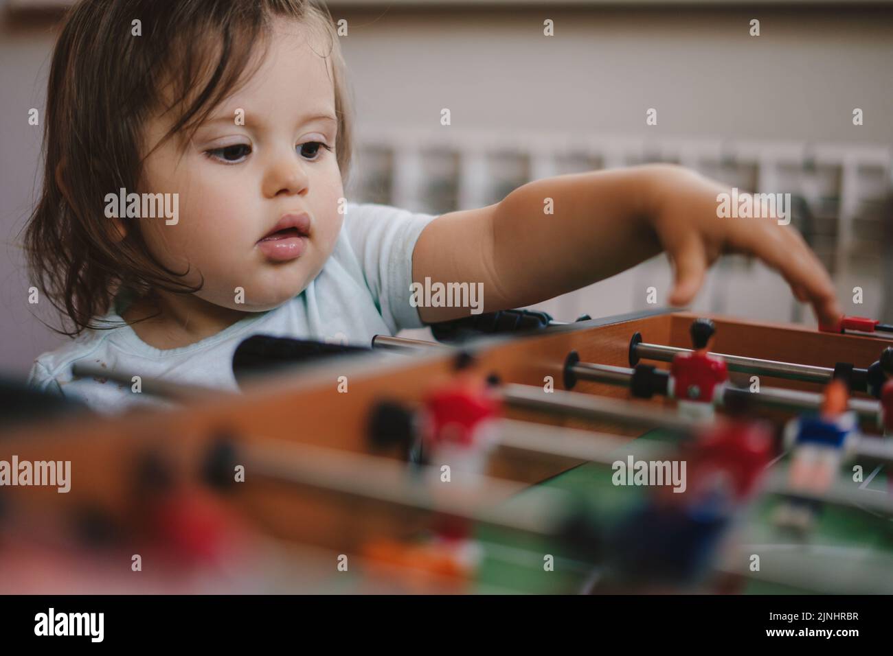 Bambina con suo fratello che gioca a calcio balilla per rilassarsi in vacanza a casa. Relax estivo. Foto Stock