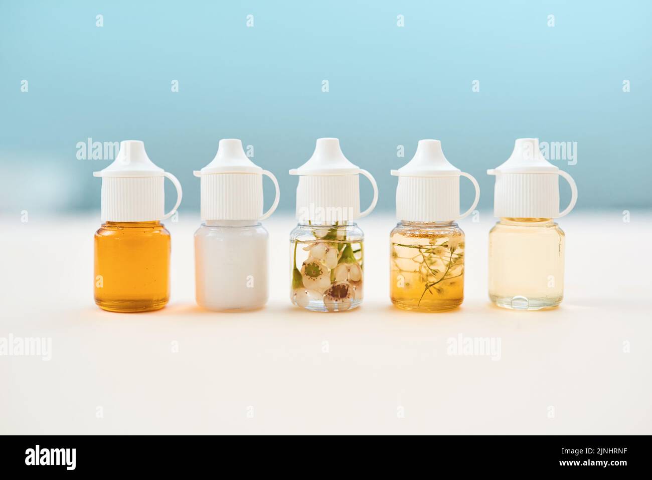 Quando la medicina moderna non funziona, provi qualcos'altro. Studio shot di forme alternative di farmaci allineati su un tavolo su uno sfondo blu. Foto Stock