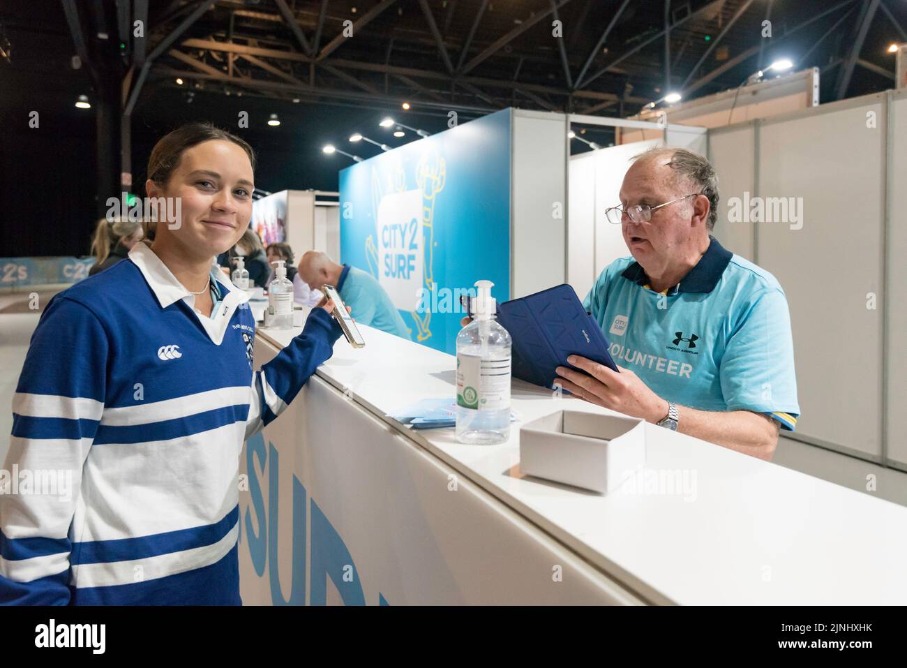 Sydney, Australia. 12 agosto 2022. Le persone che prendono parte alla gara 50th City2Surf a Sydney raccolgono i loro pettini in preparazione alla prima gara dal 2019 dopo le cancellazioni nel 2020 e nel 2021 a causa delle restrizioni del Covid-19. oltre 60.000 persone sono previste per coprire la gara di quattordici chilometri, la più grande del suo genere al mondo. La gara conduce corridori e camminatori da Hyde Park fuori dalla città, su e sopra la collina heart break e su Bondi Beach. Credit: Stephen Dwyer / Alamy Live News Foto Stock