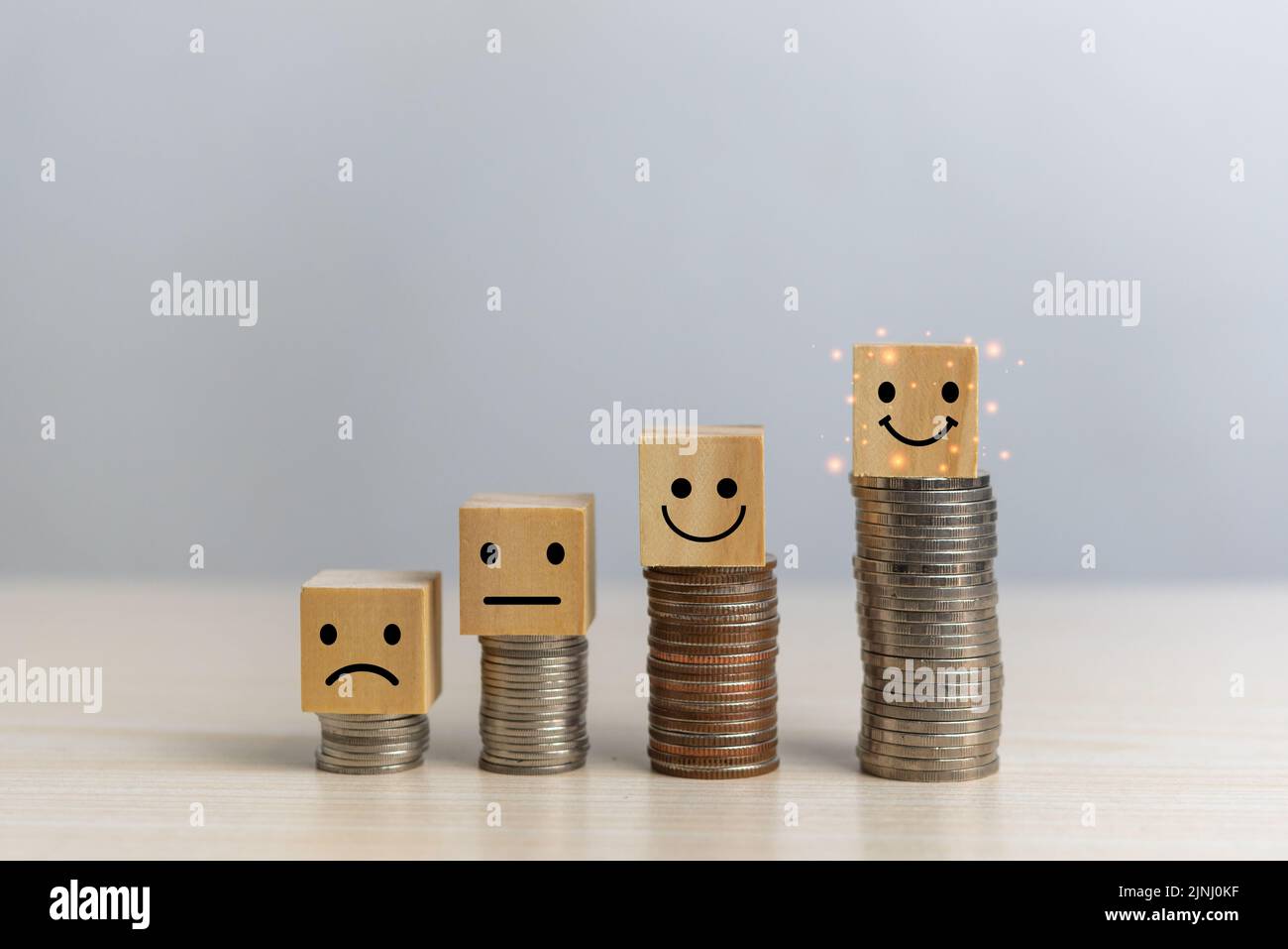 Legno blocco cubo emozione e moneta su table.Feedback raccolta statistiche risparmio finanza business concetto. Foto Stock