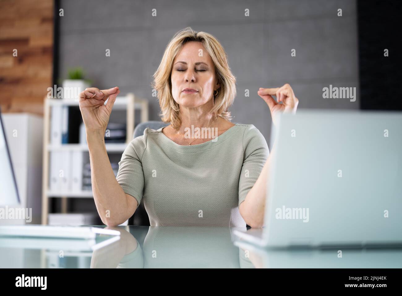 Esercizio di meditazione Yoga sana in sedia da ufficio sul luogo di lavoro Foto Stock
