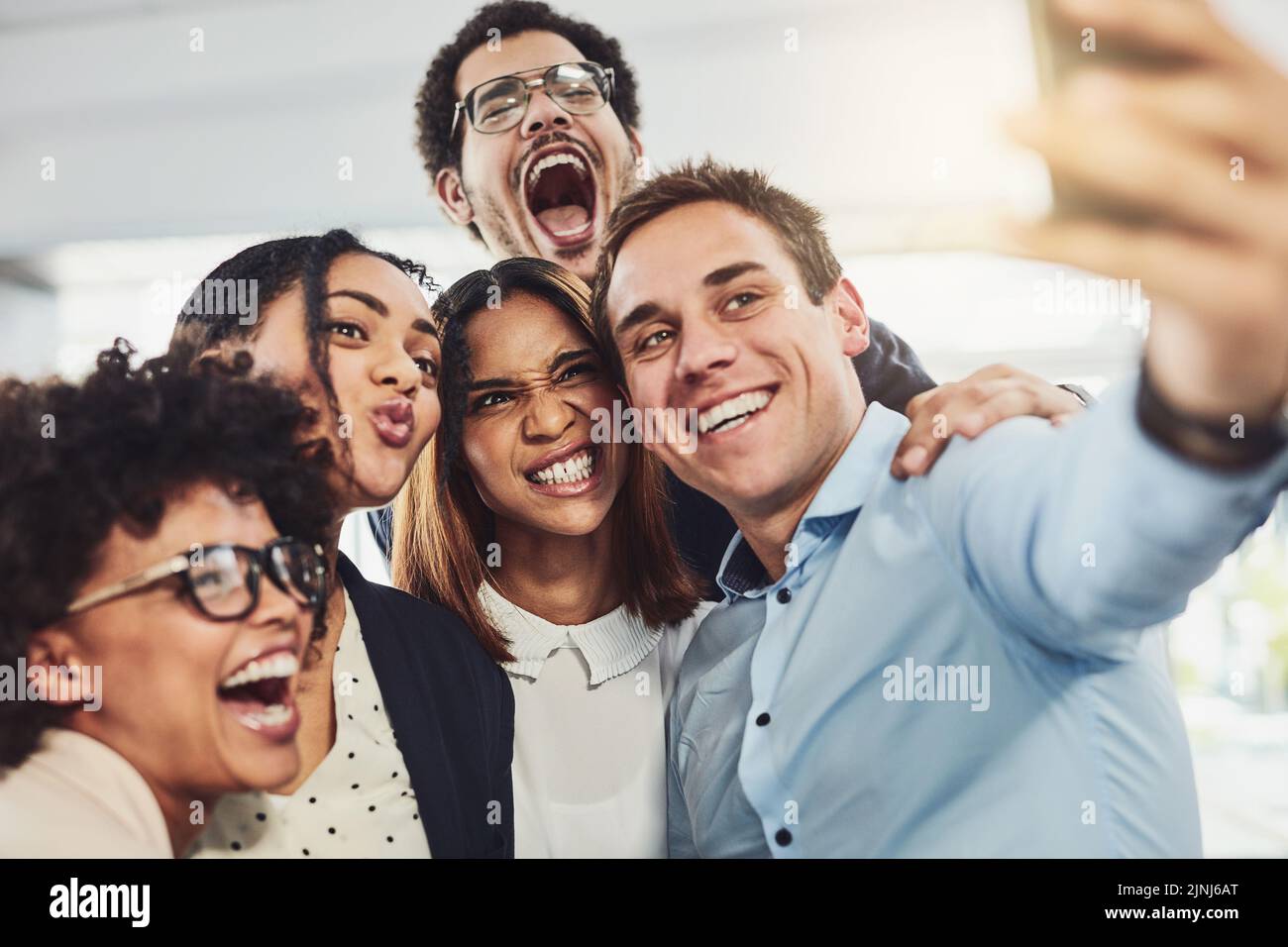 Lavoro di squadra, giocoso e selfie, mentre un gruppo di uomini d'affari allegri fare volti divertenti insieme per un post sui social media. Volti di un felice e divertente Foto Stock