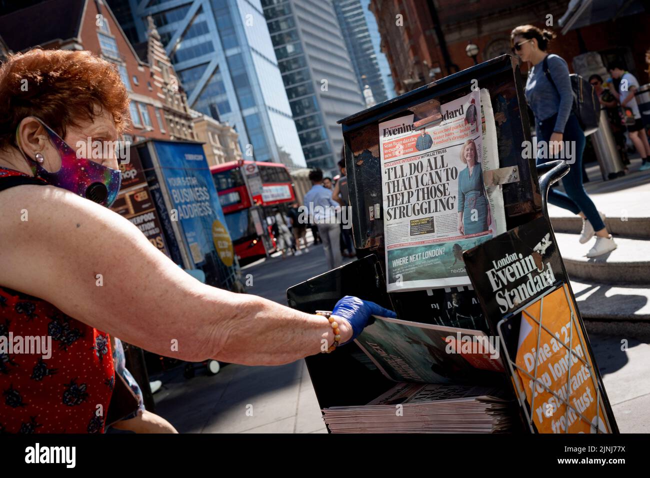 Una donna prende una copia di un giornale Standard serale il cui titolo cita il primo ministro Liz Truss durante la corsa di leadership del partito conservatore, alla stazione di Liverpool Street nella città di Londra, il quartiere finanziario della capitale (noto anche come Square Mille), il 10th agosto 2022, a Londra, Inghilterra. Foto Stock