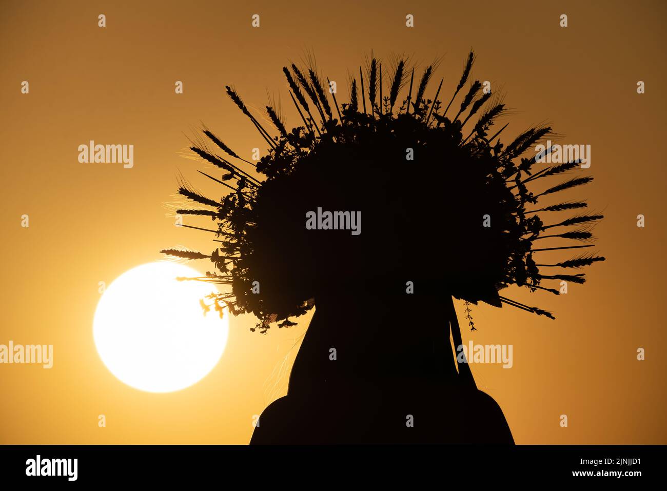 Londra, Regno Unito. 11th agosto, 2022. UK Weather: Una signora inglese-Ucraina che indossa una tradizionale corona floreale guarda il tramonto dalla cima di Greenwich Park. Credit: Guy Corbishley/Alamy Live News Foto Stock