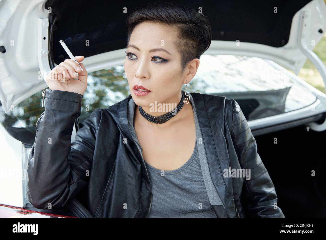 Ritratto di bella giovane donna asiatica fumando sigaretta Foto Stock