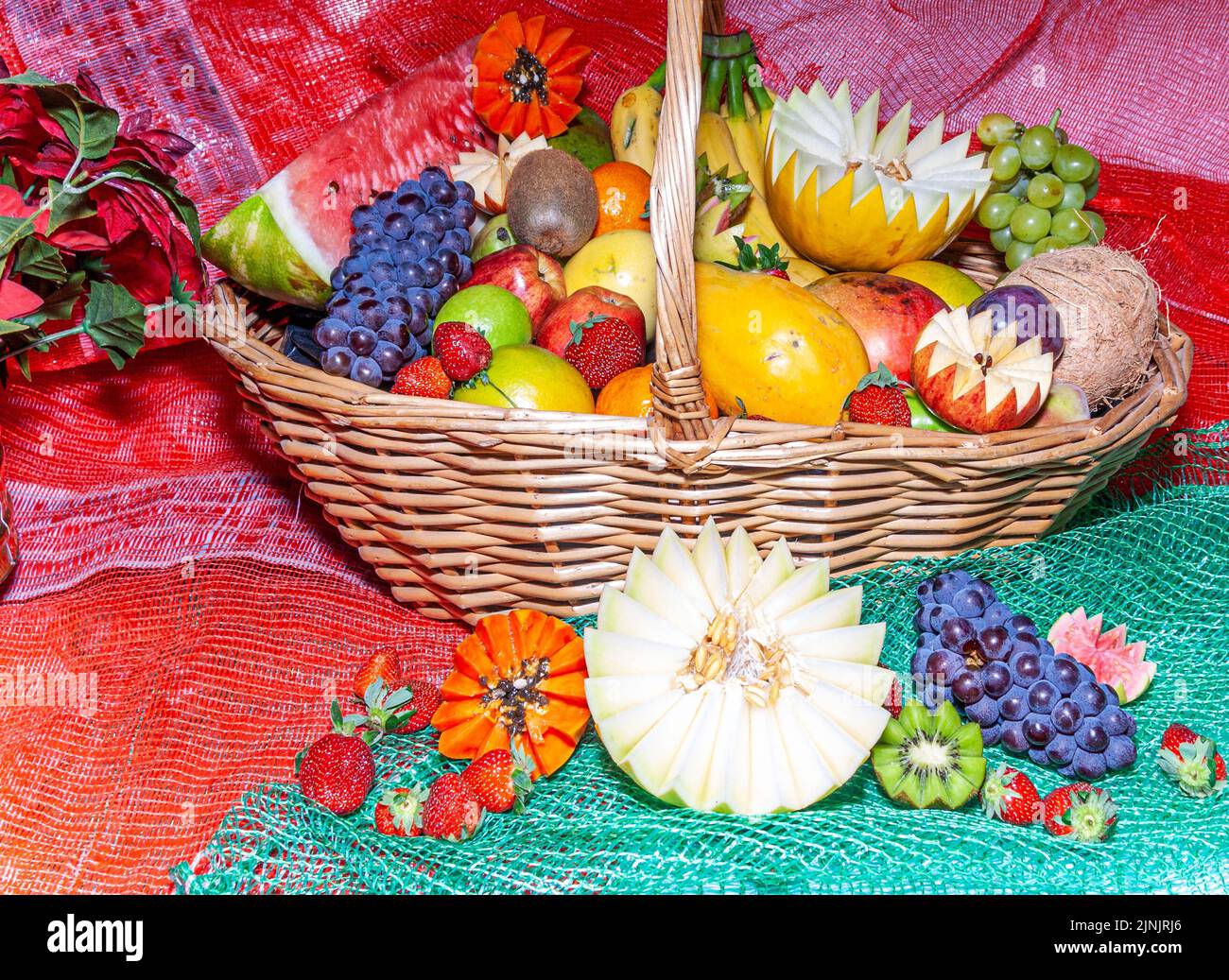 Frutta varia in un cestino decorato. Cestino decorato con diversi frutti con tagli decorativi. Foto Stock