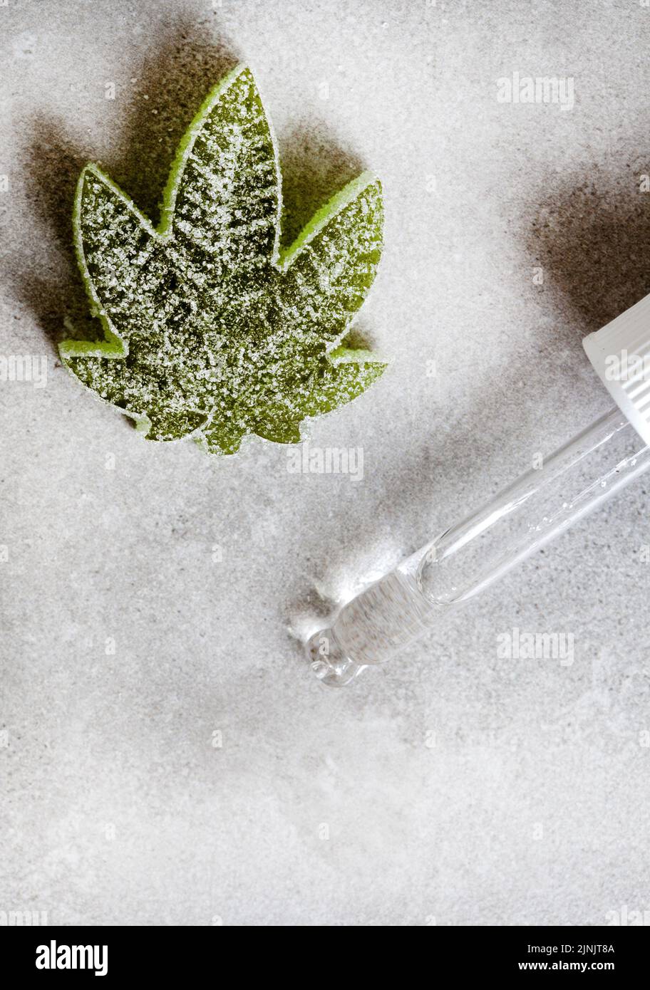 CBD e Cannabis infondono caramelle di gelatina su superficie grigia con spazio di copia Foto Stock