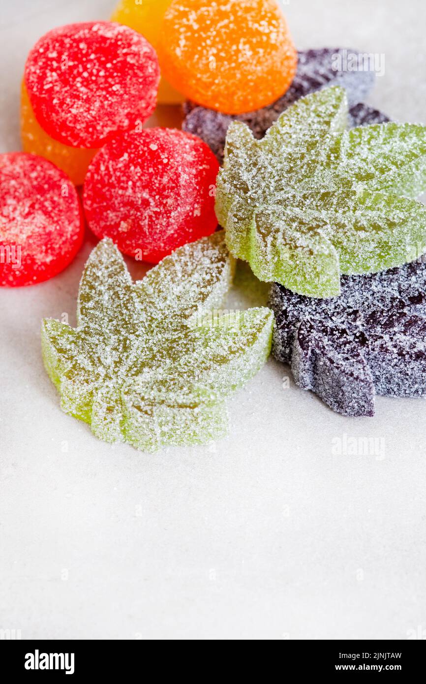 CBD e Cannabis infondono caramelle di gelatina su superficie grigia con spazio di copia Foto Stock