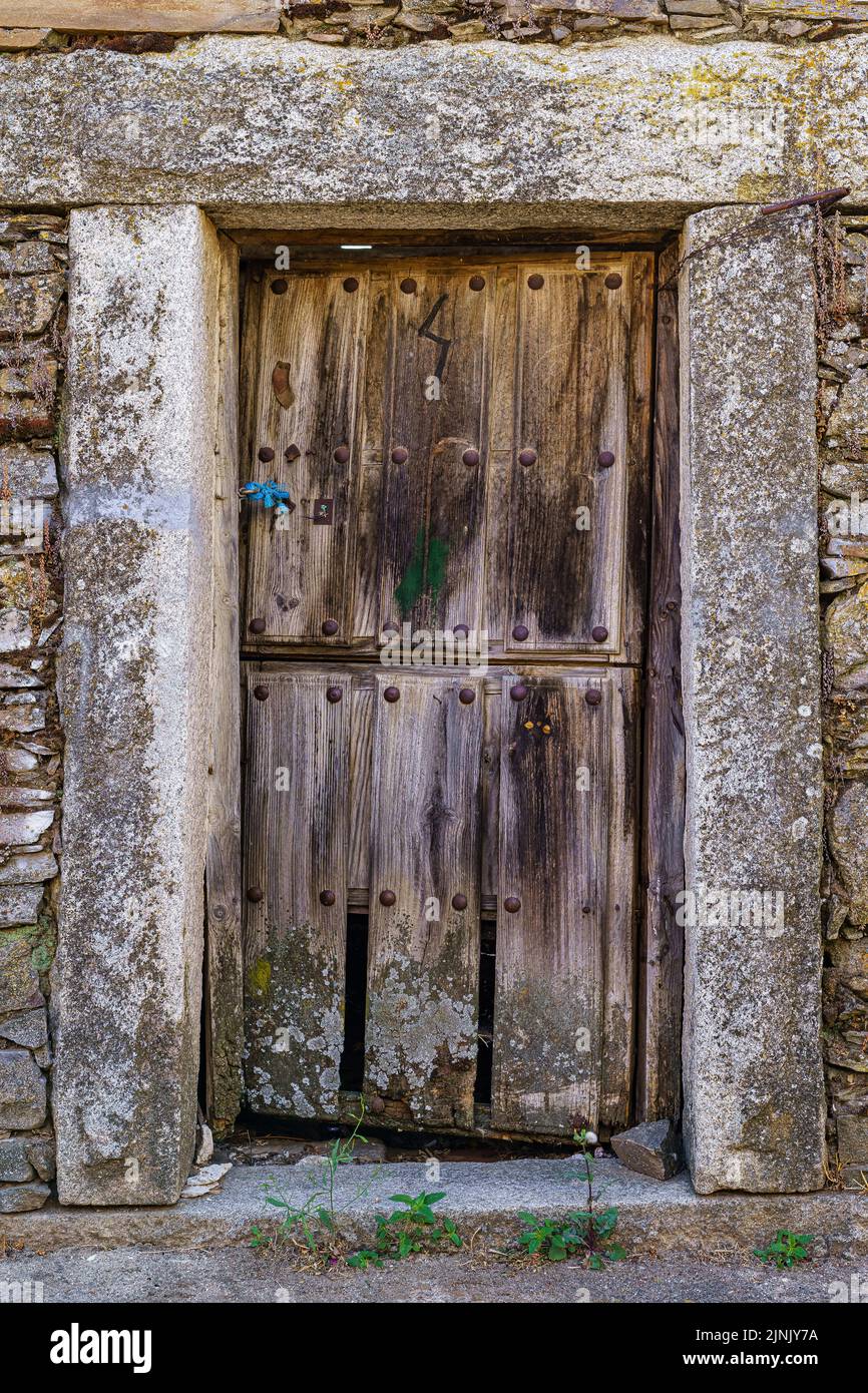 Vecchia porta in legno in casa medievale in pietra. Foto Stock