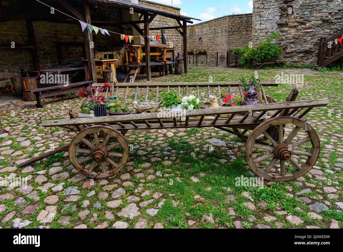 Carrozza dall'aspetto molto vecchio con varie decorazioni su una strada acciottolata molto vecchia. Foto Stock