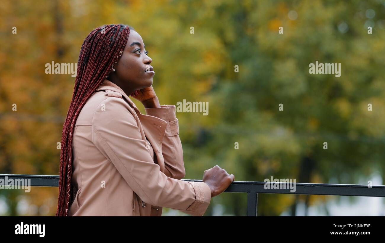 Pensieroso rovesciato giovane donna si alza all'aperto guardando al lato pensa al futuro profondo nei pensieri respirare aria fresca pensare di personale Foto Stock